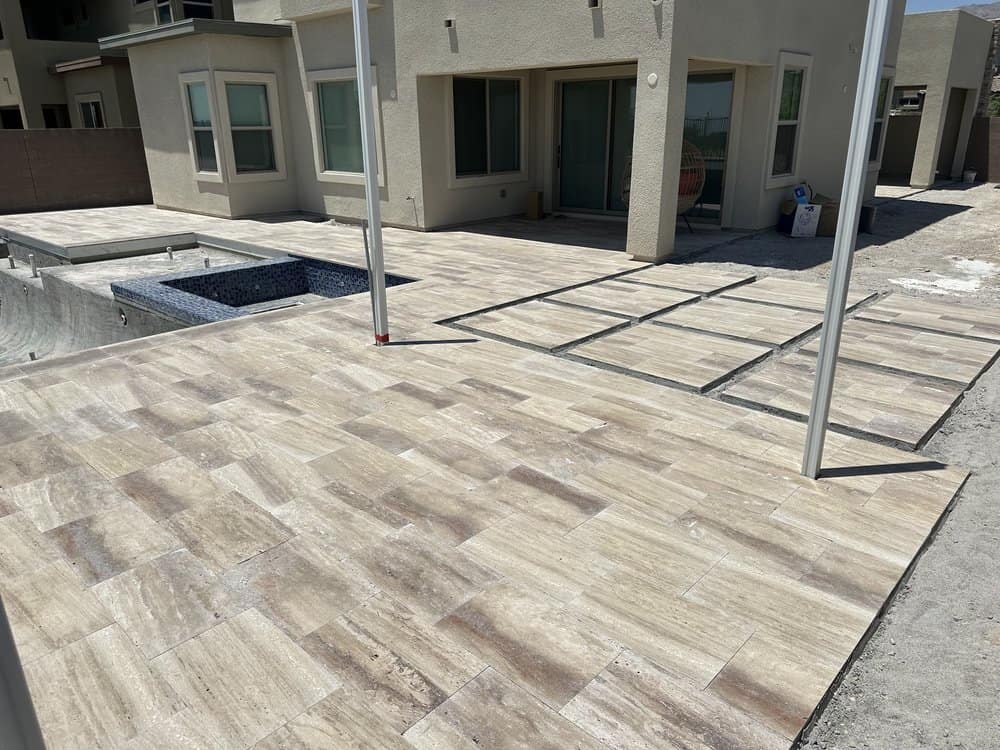 A backyard patio with stamped concrete resembling wood, surrounded by greenery. beautiful decorative concrete
